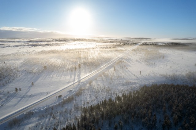 Droonivaade lumiselt talvisele Svalbard maastikule ja seda läbivale sõiduteele, Norra